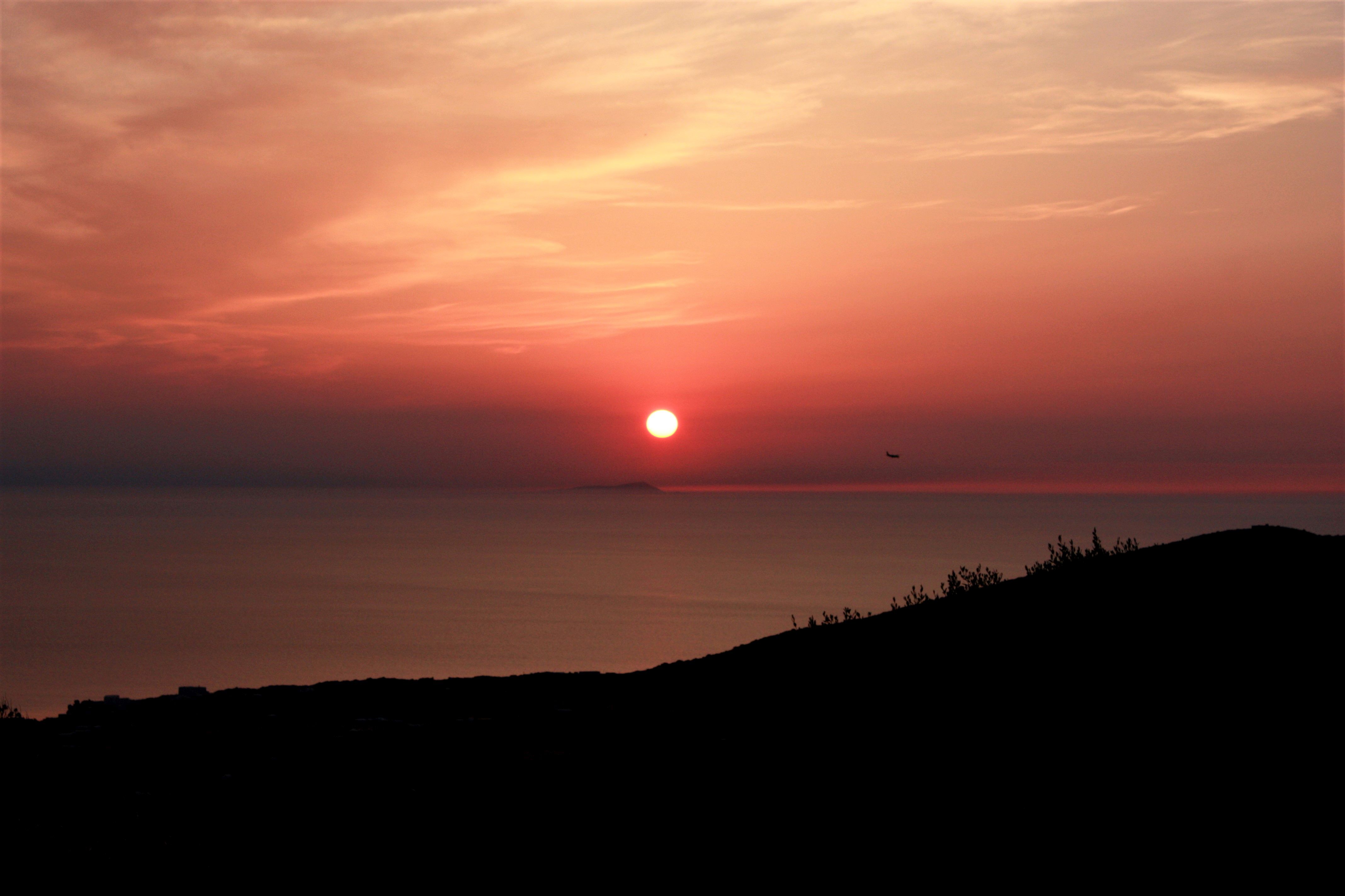 Tramonto con la Tunisia e un aereo in arrivo a Pantelleria